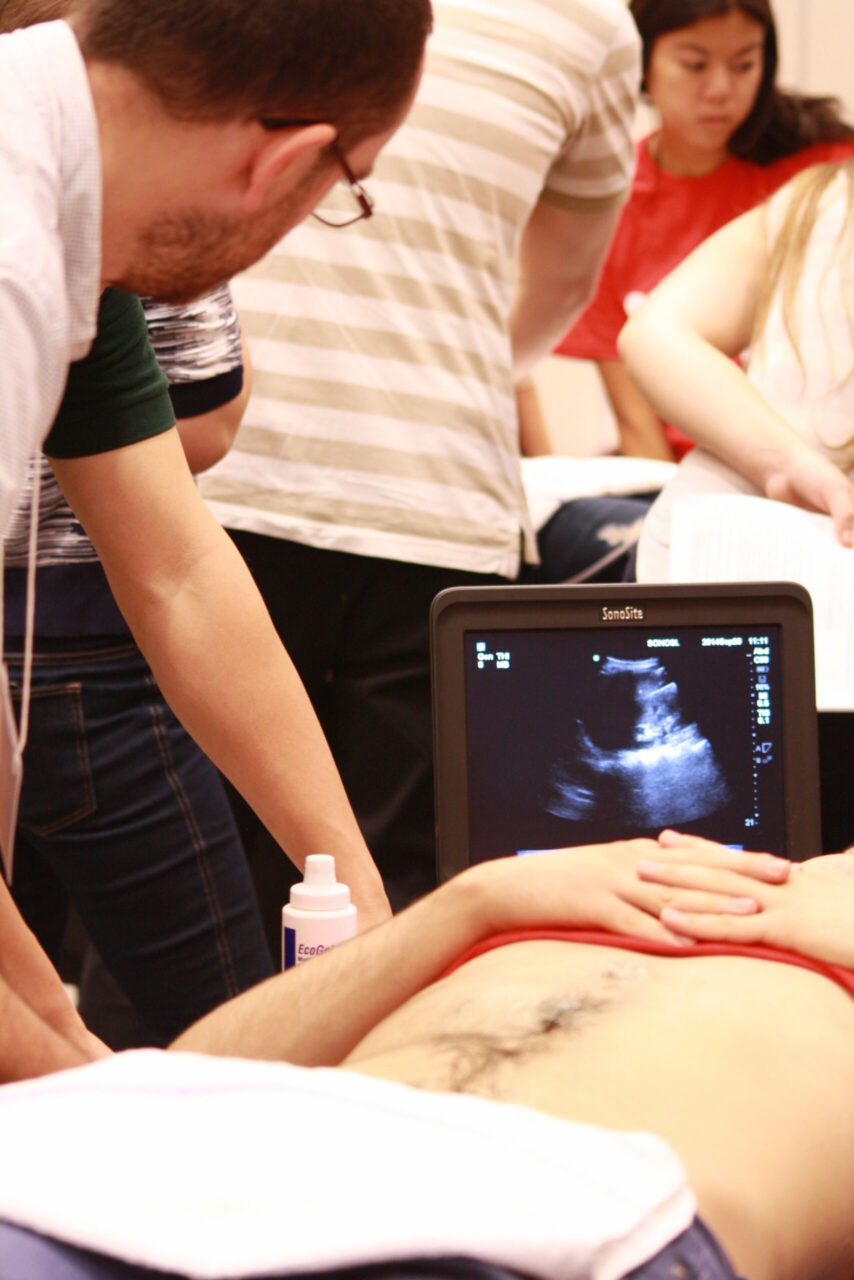 Student practicing his fast echography skills on a volunteer model. (Photo: Annelise Miller)