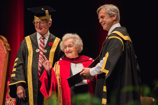 Brenda Milner accepts her Honorary Degree, Doctor of Laws, from Robert Thirsk, Chancellor of the University of Calgary. Michael A. Meighen, McGill’s Chancellor looks on. / Photo: Alison Slattery Photography.